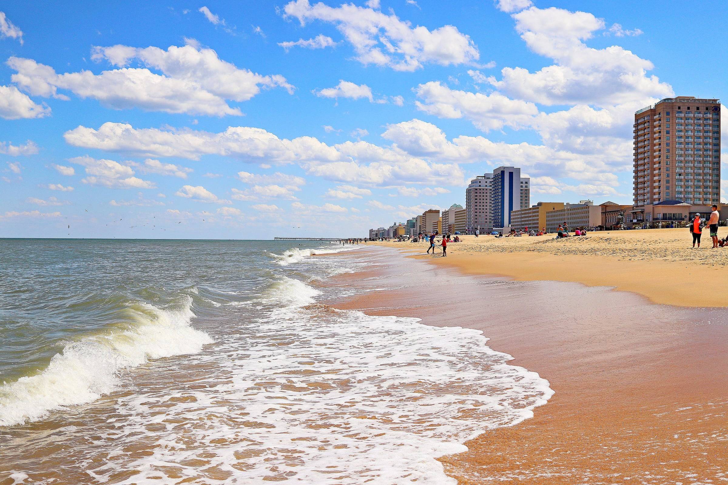 Waves breaking on the sand at the Virginia Beach Oceanfront, with hotels lining the beach